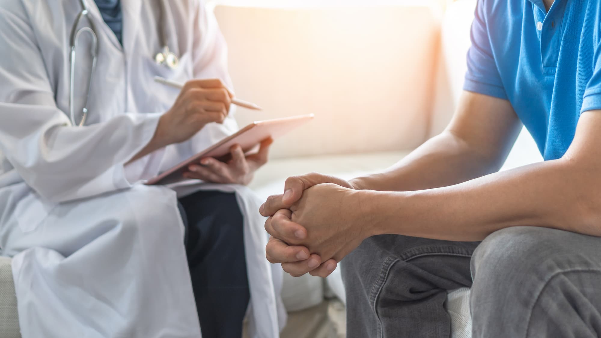 a nurse chatting to a male patient with a list in hand